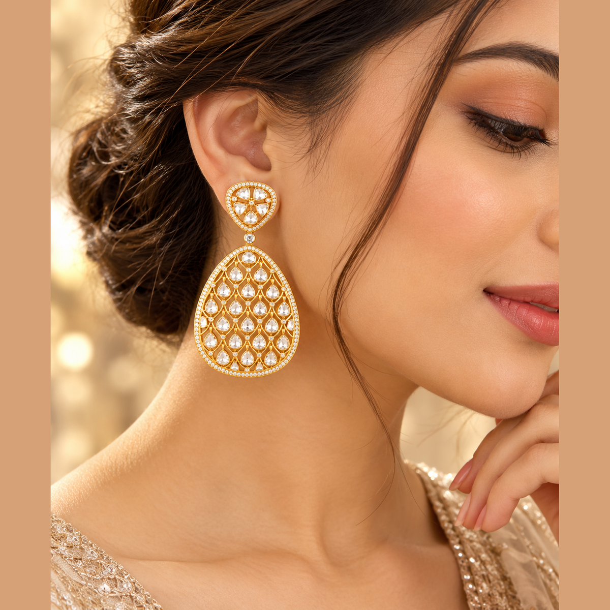 Gold-tone teardrop dangle earrings with clear sparkling stones and intricate openwork design