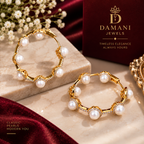 Gold pearl statement hoop earrings styled on a model
