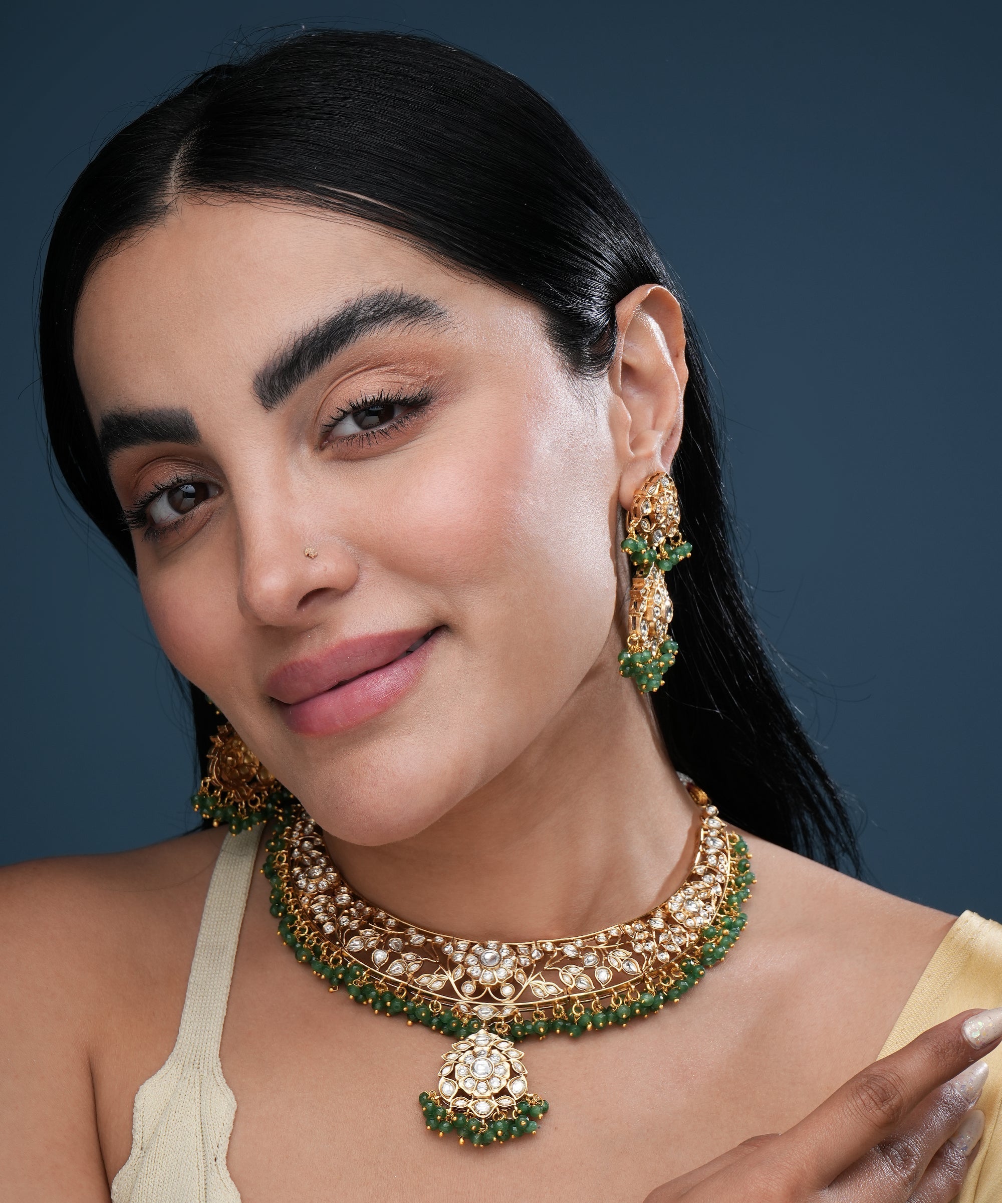 Traditional gold kundan choker necklace set with green bead detailing, matching earrings, and adjustable dori closure for women.