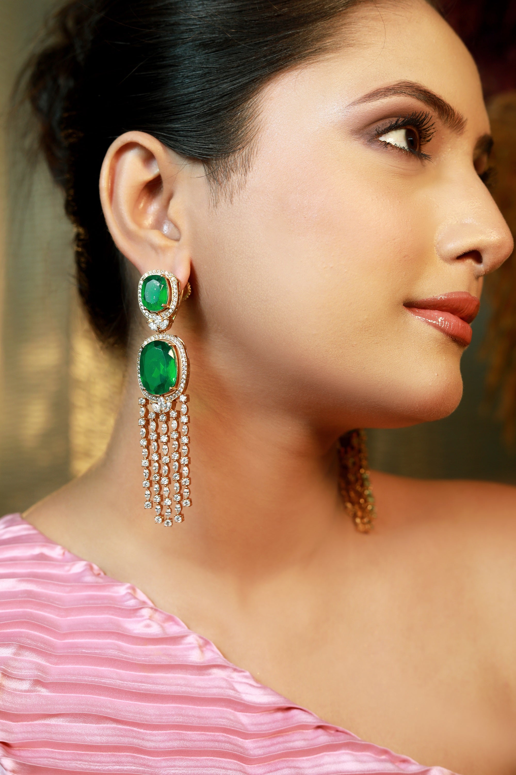 Close-up of emerald green long CZ earrings with diamond drop chains on model — Damani Jewels luxury party wear jewellery