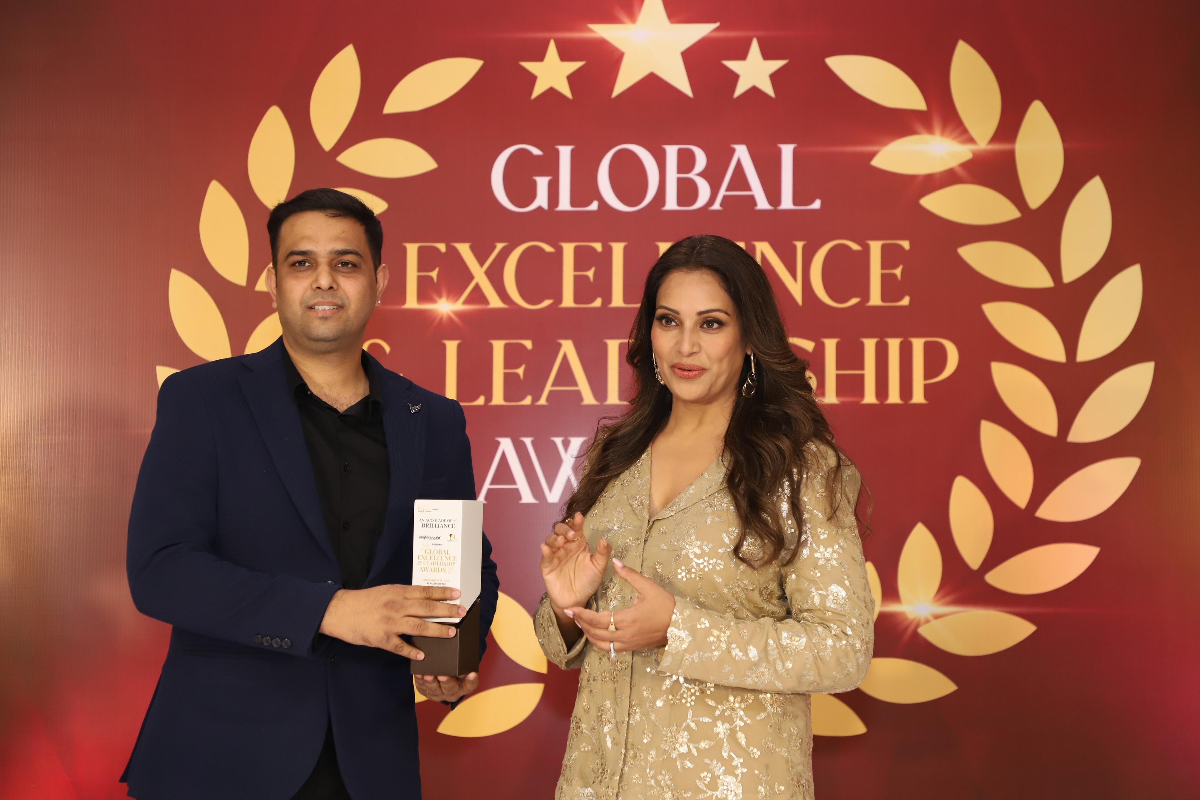 Founder Vishal receiving the Global Excellence Leadership Award 2025 during an award ceremony, standing beside the event’s chief guest on a red and gold backdrop.