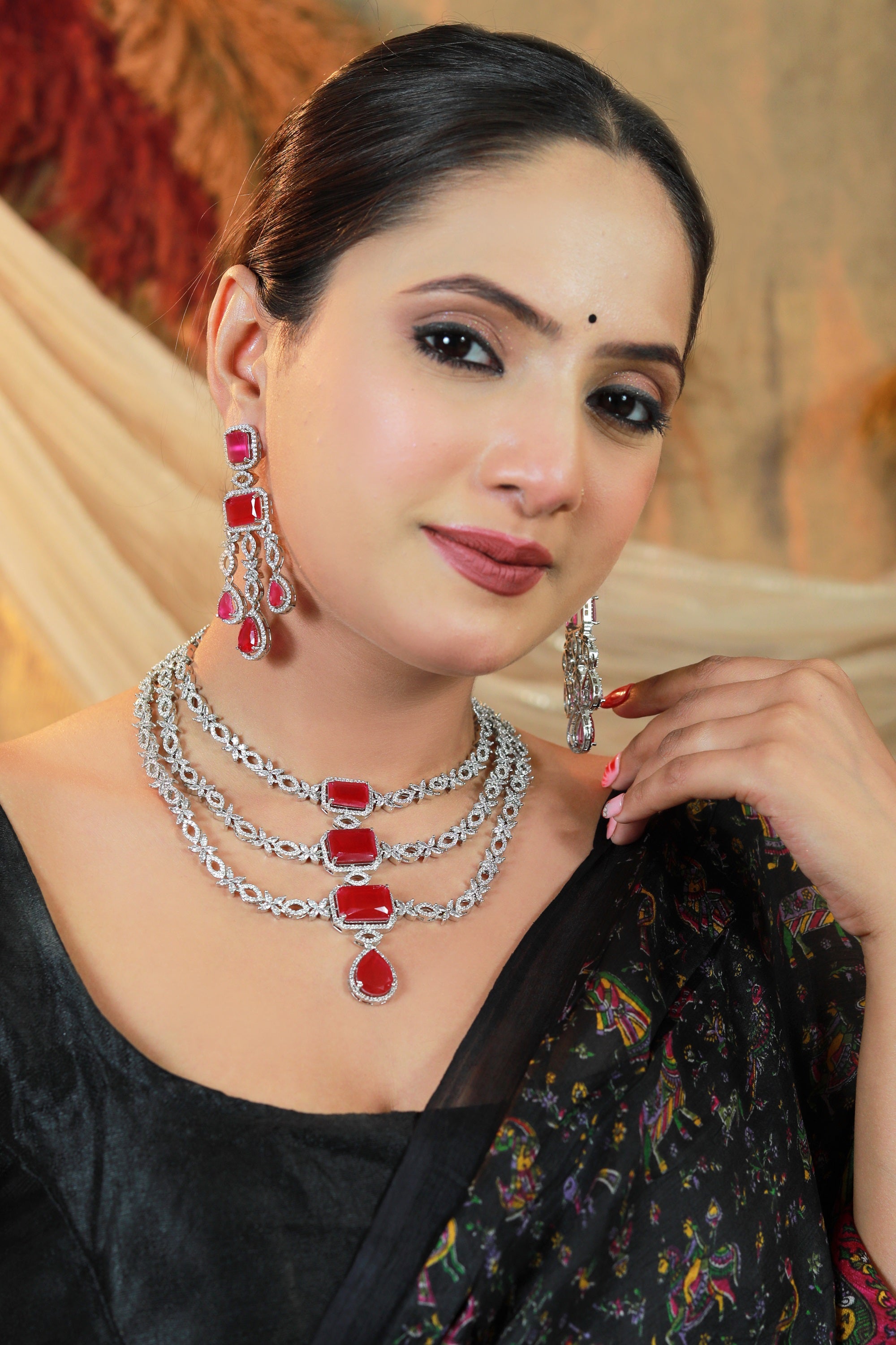 Front view of triple-layer silver necklace with CZ diamonds and ruby stones