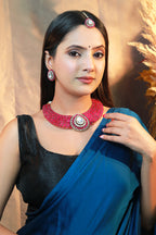“Woman wearing a pink stone choker necklace set with kundan centerpiece, matching earrings, and maang tikka.”