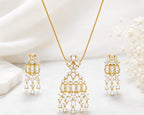 Luxury gold-tone crystal pendant necklace with matching chandelier drop earrings featuring baguette and pear-cut stones for bridal and party wear.