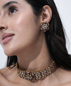 Designer Moissanite choker necklace featuring floral motifs, sparkling white stones, pink accents, and matching stud earrings.