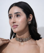 Traditional wedding jewelry set with floral Moissanite choker necklace and matching pink stone earrings in gold-tone finish.