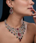 Elegant party wear statement necklace and earrings set with ruby, emerald, and crystal accents