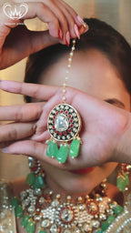 “Bridal Kundan necklace set with white stones, ruby accents, and emerald-green bead drops including matching earrings and maang-tikka.”