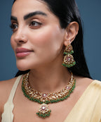Traditional golden kundan choker necklace set with green bead detailing, pink stone accents, matching earrings, and adjustable dori closure for women.